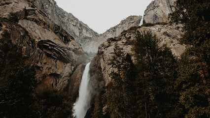 Beautiful view of a waterfall in a forest under the cloudy sky
