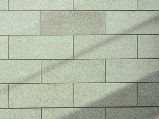 タイル壁と浮かぶ影