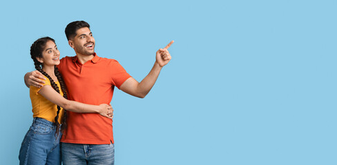 Check This Offer. Happy Middle Eastern Couple Embracing And Pointing Aside