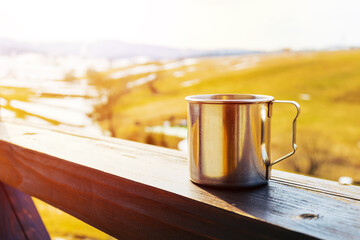 morning coffee or tea cup on balcony over sunny mountain background. copy space. spring season. travel landscape. hot drink pleasure concept