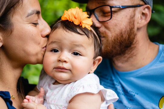 latin family kissing their baby