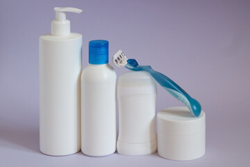 Various cosmetic products with deodorant. Beauty care accessories, shaving set with razor and shaving cream on blue background.