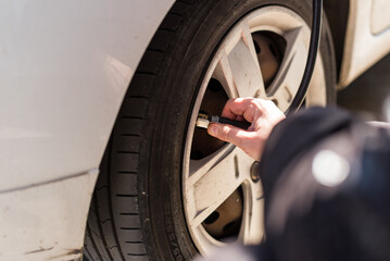 Woman's hand inflating car tire  © machirito