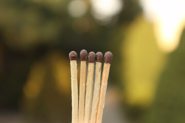 Matches in hand, fingers holding matches. Matches on the background. Unburned matches