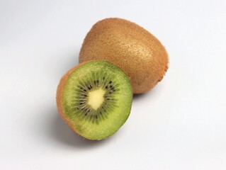 Obraz premium One whole and half kiwi cut. Close-up, light gray background, selective focus.
