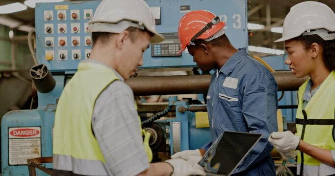 Group of machine technicians are profession  inspect the electrical equipment in factory. Industrial plant engineers plan machine maintenance. African American workers work with Asian team Blue collar