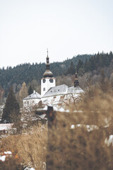 Vertical shot of a church in Spania Dolina, Slovakia in winter - obrazy, fototapety, plakaty