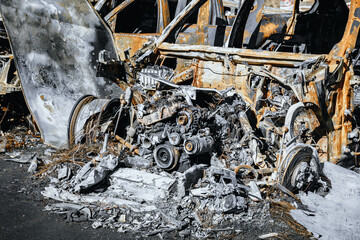 Photo of engine and under the hood space of burned car. Metal remains of the automobile. Arson of a...