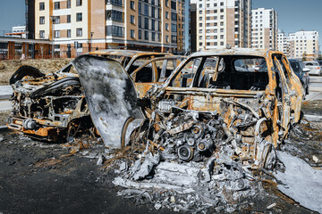 Remains of burnt cars near with residential buildings. Arson of a car. View on front part of...