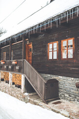 Vertical shot of a wooden textured house in Spania Dolina, Slovakia in winter - obrazy, fototapety, plakaty