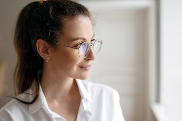 Portrait of a brunette woman with eyeglasses looking away