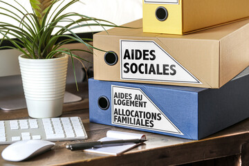 pile de dossiers aides sociales, Aides au logement, allocations familiales sur un bureau