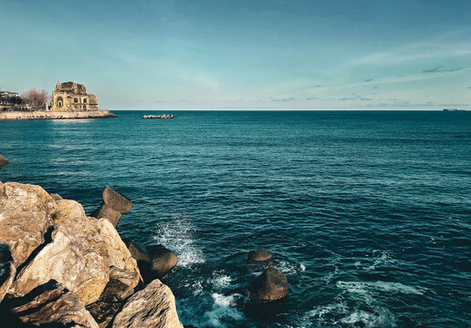 Beautiful view of an old building by the sea under a blue sky in Constanta, Romania