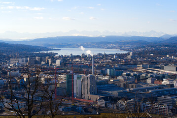 Fototapeta na wymiar Aerial view over City of Zürich with Lake Zürich and Swiss Alps in the background on a blue and cloudy spring morning. Photo taken March 14th, 2022, Zurich, Switzerland.