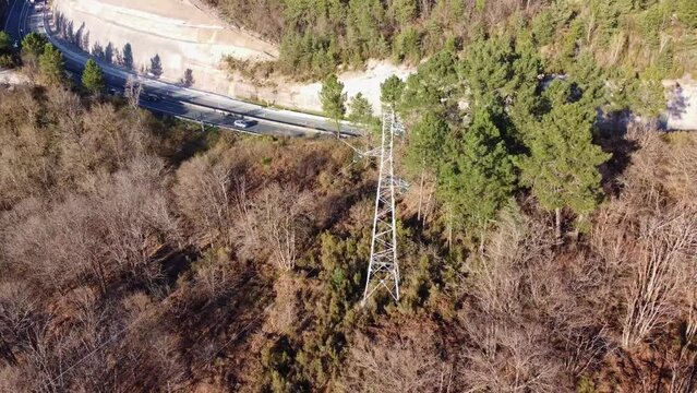 Pyl&ocirc;ne &eacute;lectrique vu du ciel avec l'autoroute passant derri&egrave;re. Pyl&ocirc;ne &eacute;lectrique situ&eacute; en pleine for&ecirc;t.