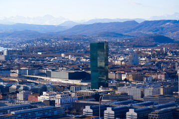 Aerial view over City of Zürich with Prime Tower skyscraper and industrial area and mountains in the background on a blue and cloudy spring morning. Photo taken March 14th, 2022, Zurich, Switzerland.