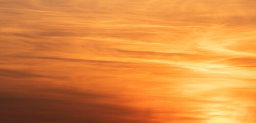 Beautiful dark golden sunset sky with clouds. Sky background.