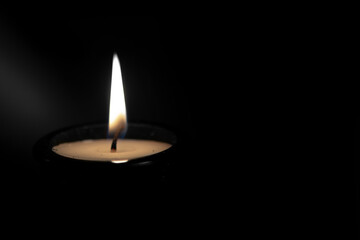 Burning candle  against black background