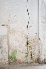 Parede desconchada y vieja con humedades, tubería, con manómetro y grifo