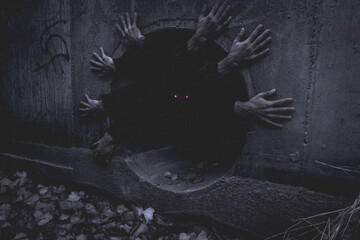 Creepy creature with multiple hands looking from the dark hole.