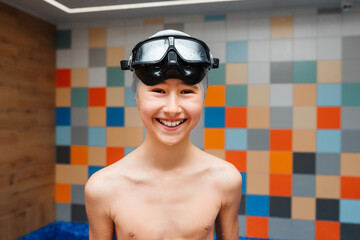 Close-up portrait of cheerful happy male child in swimming mask. Children in the water park.