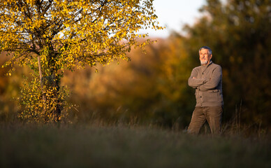 Portrait of handsome senior man in the autumn outdoors. Active senioor enjoying his retirement in the  nature