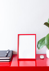 Red frame on a white background with a flower and notebooks. Design. Mock-up. Copy space.