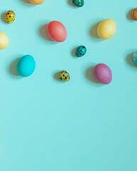 Colorful painted Easter eggs on the blue background. Top view. Copy space	