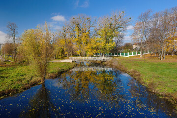 Fototapeta na wymiar Autumn scenery of public park and Okhtyrka river in Okhtyrka, Ukraine