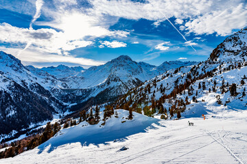 Sunny day and lots of snow at ski resort in the Swiss alps of the Vallees, Switzerland