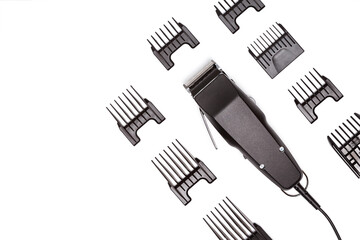 Professional hair clipper with set of nozzles of different sizes isolated on white background. Top view. Copy space for text