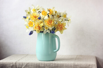 bouquet of yellow daffodils in a blue jug