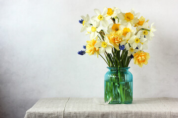 bouquet of yellow daffodils in a glass vase on a table.