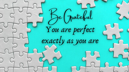 Inspirational quote text on missing jigsaw puzzle - Be grateful. You are perfect exactly as you are.