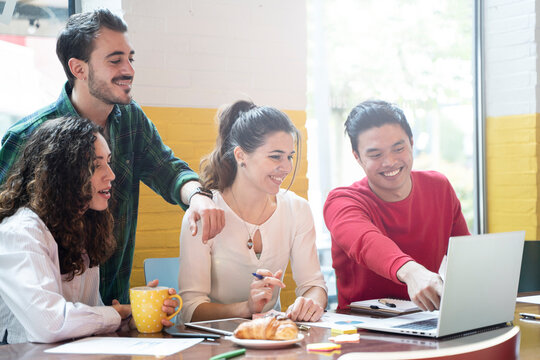 Young co-workers multiethnic team planning a new startup - Happy people working on a new project in creative coworking office - Marketing concept - Bright filter with focus on woman face at center