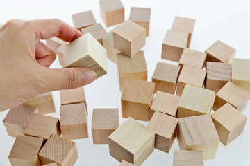 Human hand picking up a wooden block