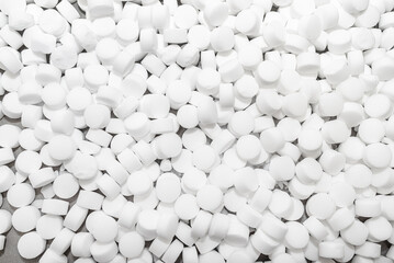 Background made of salt tablets for a water softener, large round cubes.