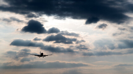 Fototapeta na wymiar Airplane flying in overcast sky
