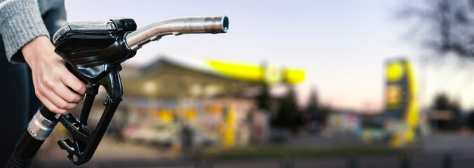 Closeup of woman pumping gasoline fuel in car at gas station. Petrol or gasoline being pumped into...