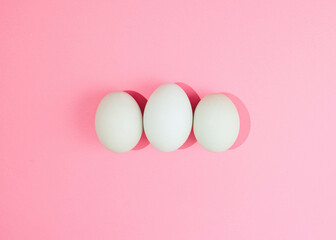 Three white eggs ready for breakfast.Easter composition