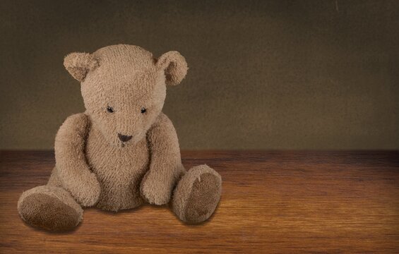 Brown little bear on a old wooden desk.