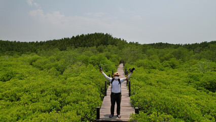 Portrait A man tourist  travel to Mangrove forest , study natural and environment , Tung Prong Thong Forest located at Pak Nam Prasea in Rayong of Thailand
