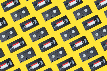 VHS video cassette, Old black videotape pattern on a yellow background, Outdated technology background. - obrazy, fototapety, plakaty