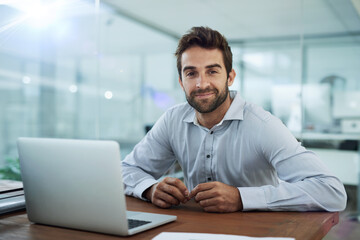 Fototapeta premium Hes working on some new ideas. Portrait of a young corporate businessman sitting in front of a laptop in an office.
