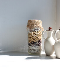 Transparent jar of beans stands in the kitchen. Legumes are a useful product for health