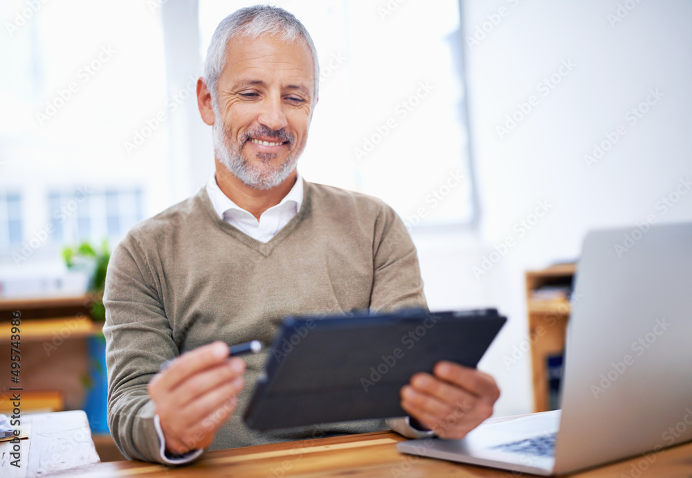 Aufkleber this months numbers are excellent. a happy businessman using a tablet at his desk at work.