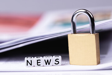 newspaper, cubes with word News and metal lock closeup