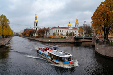 View of the Naval Cathedral of St. Nicholas on the Griboyedov Canal and a pleasure boat on an...