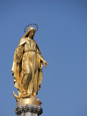 Fototapeta na wymiar Vertical picture of a Holy Mary statue placed on top of a column in front of Zagreb Cathedral, Croatia