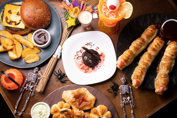 gloomy table set for with delights for halloween top view with bat candy chocolate dessert